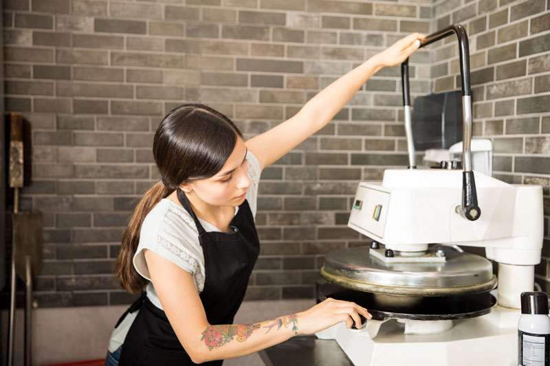woman using pizza dough press